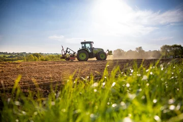 Papier Peint photo Tracteur Machine agricole au travail dans les champ pendant les semences de printemps.