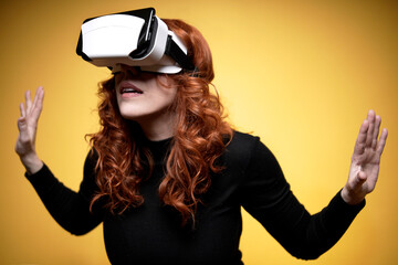 woman with virtual reality goggles on yellow background and open arms