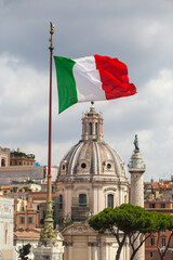 Italian flag waving on the wind in front of historical building in Rome, Italy