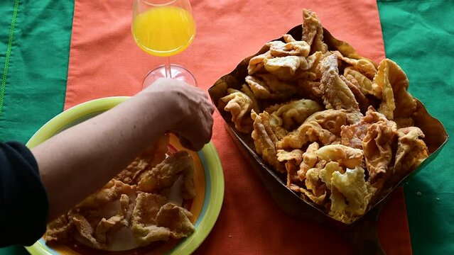 Footage with a table laden with lies or chiacchiere, a typical sweet of the carnival in Italy. Concept of traditional and local food, party , enjoy party time.