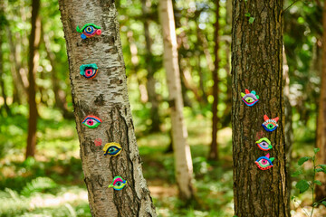 Art object of human eyes on tree trunk in green forest background, trees sight feeling ecological...