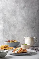 Greek zucchini fritters Kolokithokeftedes on gray background. Zucchini pancakes with feta and herbs, served with greek yogurt.