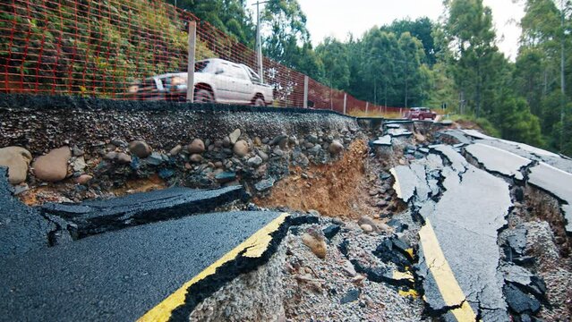 Damaged asphalt road in the mountains. Mudflow aftermath, cracked paved road