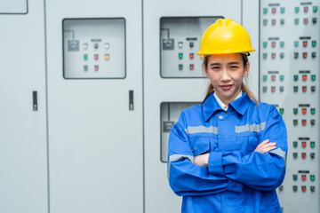 Asian woman engineer of mechanical standing in front of  machine panel on site working. Worker has...