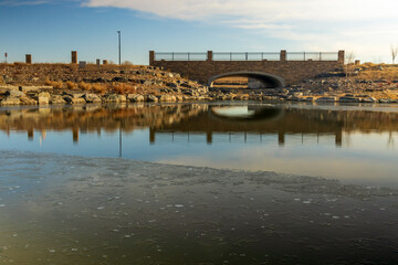 Obraz premium Beautiful early spring landscape with a pond and reflections in the small neighborhood park in Aurora, Colorado