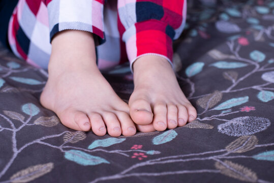 Bare feet of a child. Foot. Children in pajamas in bed