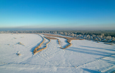 Amazing winter views of the Vecdaugava nature reserve.  A snowy meadow with a pattern of reeds.
