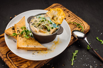 Fresh onion cream soup and crottons on wooden background