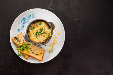 Fresh onion cream soup and crottons on wooden background