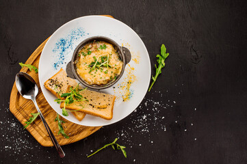 Fresh onion cream soup and crottons on wooden background