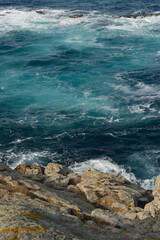 Blue sea with waves along the rocky shore