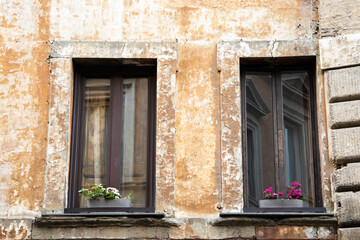 Fototapeta na wymiar Roman window on the ochre color building