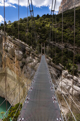 Fototapeta na wymiar Hanging bridge in Congost de Mont Rebei, mountain gorge with azure river, hiking in Aragon, Spain