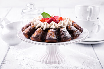 Traditional German strawberry cheese cake with fresh fruits and white chocolate cream served as close-up on a cake plate