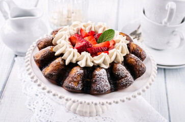 Traditional German strawberry cheese cake with fresh fruits and white chocolate cream served as close-up on a cake plate
