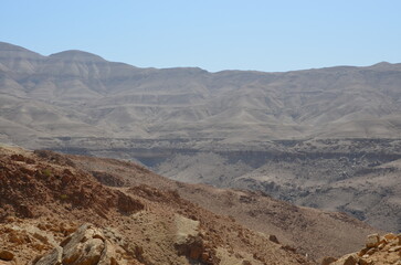 Panoramic view of the rocks, canyons and the desert and dry landscape surrounding Madaba, Jordan, on a bright sunny day.