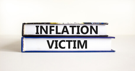 Inflation victim symbol. Concept words Inflation victim on books. Beautiful white table white background. Business inflation victim concept. Copy space.
