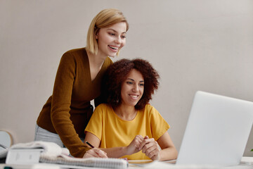 Two women colleagues in office working together.