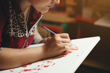 Girl paints a picture by numbers with paints