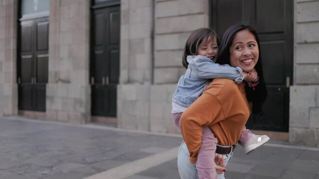 Asian mother and child daughter having fun together outdoors in the city - Family and love concept
