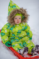 A little girl is sledding in the harsh northern winter