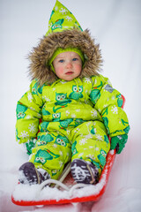 A little girl is sledding in the harsh northern winter