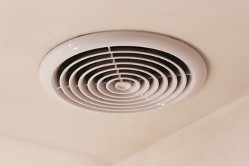 Ventilation grille, round, white, integrated into the white ceiling