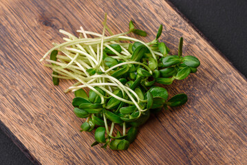 Fresh sprouts or sunflower microgreens on wooden cutting board