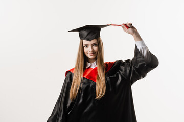 Graduate girl with master degree in black graduation gown and cap on white background. Happy young woman successfully graduated from the university with honors.
