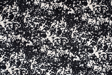 A fabric with a textured pattern of black and white spots, like an image of a wild animal skin...