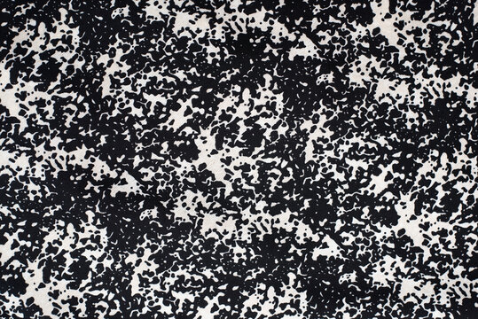 A fabric with a textured pattern of black and white spots, like an image of a wild animal skin print in toned colors, or an image of a dalmatian skin © Мар'ян Філь