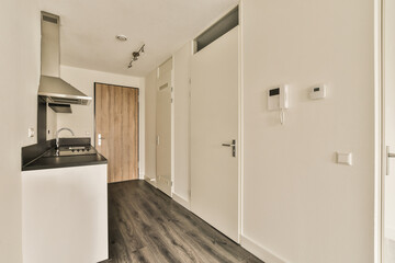 an empty room with wood flooring and white walls on the right side of the room, there is a sink in...