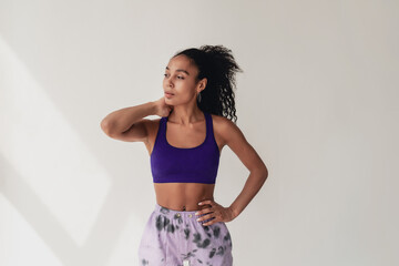 attractive black african american woman in stylish hipster fitness outfit on isolated background