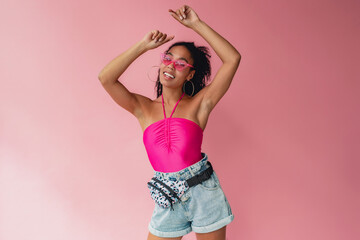 attractive black african american woman in stylish outfit on pink background