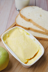 fresh butter in a container with bread on white background 