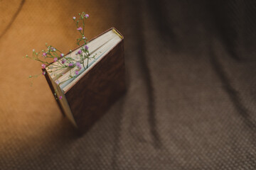 Still life with old book and dried flowers on dark vintage background top view. Flat lay styling.