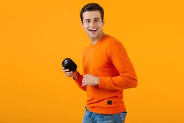 stylish young man holding wireless speaker