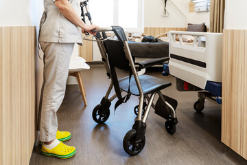 Nurse brought a wheelchair to a stylish hospital room. The concept of patient care, comfortable movement.