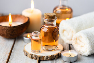 Fototapeta na wymiar Concept of spa treatment in salon with pure organic natural oil. Atmosphere of relax, detention. Aromatherapy, candles, towel, wooden background. Skin care, body gentle treatment