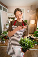 One young woman take care of plant and photos with her smartphone