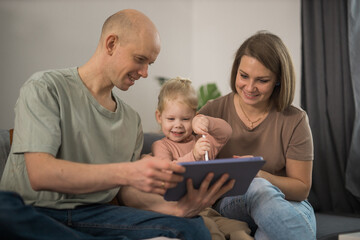 Deaf child girl with cochlear implant studying to hear sounds and have fun with mother and father - recovery after cochlear Implant surgery and rehabilitation concept