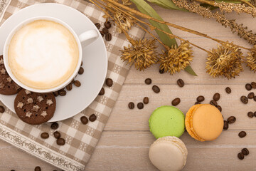 Fototapeta na wymiar Decoration with coffee and macaroons on wooden background. A moment of rest. Coffee shop. View from above.