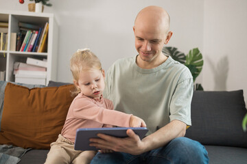 People with cochlear implant system. Kid study to hear with her father, learning with video on...