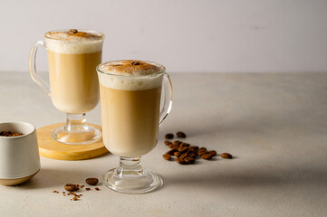 Two cups with coffee drink, latte or mocha with milk foam and cinnamon. Copy space