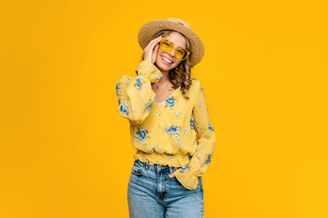 stylish happy smiling blond woman on vacation in straw on yellow background