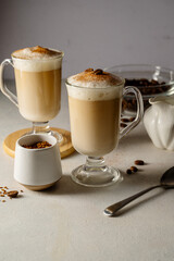 Two cups with coffee drink, latte or mocha with milk foam and cinnamon