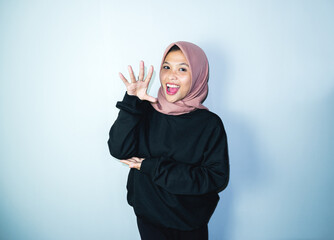 Excited Asian Muslim woman celebrating victory isolated over white background