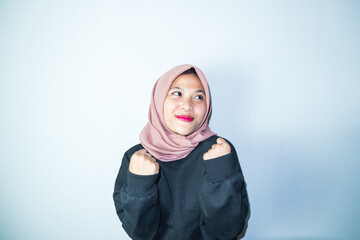 Excited Asian Muslim woman celebrating victory isolated over white background