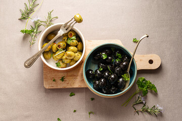 Black and green olives in bowls. Delicious, marinated olives. Top view. - Powered by Adobe