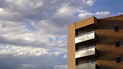 facade with glass balconies against cloudy sky